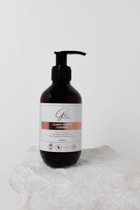 Glo Younger Clarity Enzyme Cleanser bottle on stone