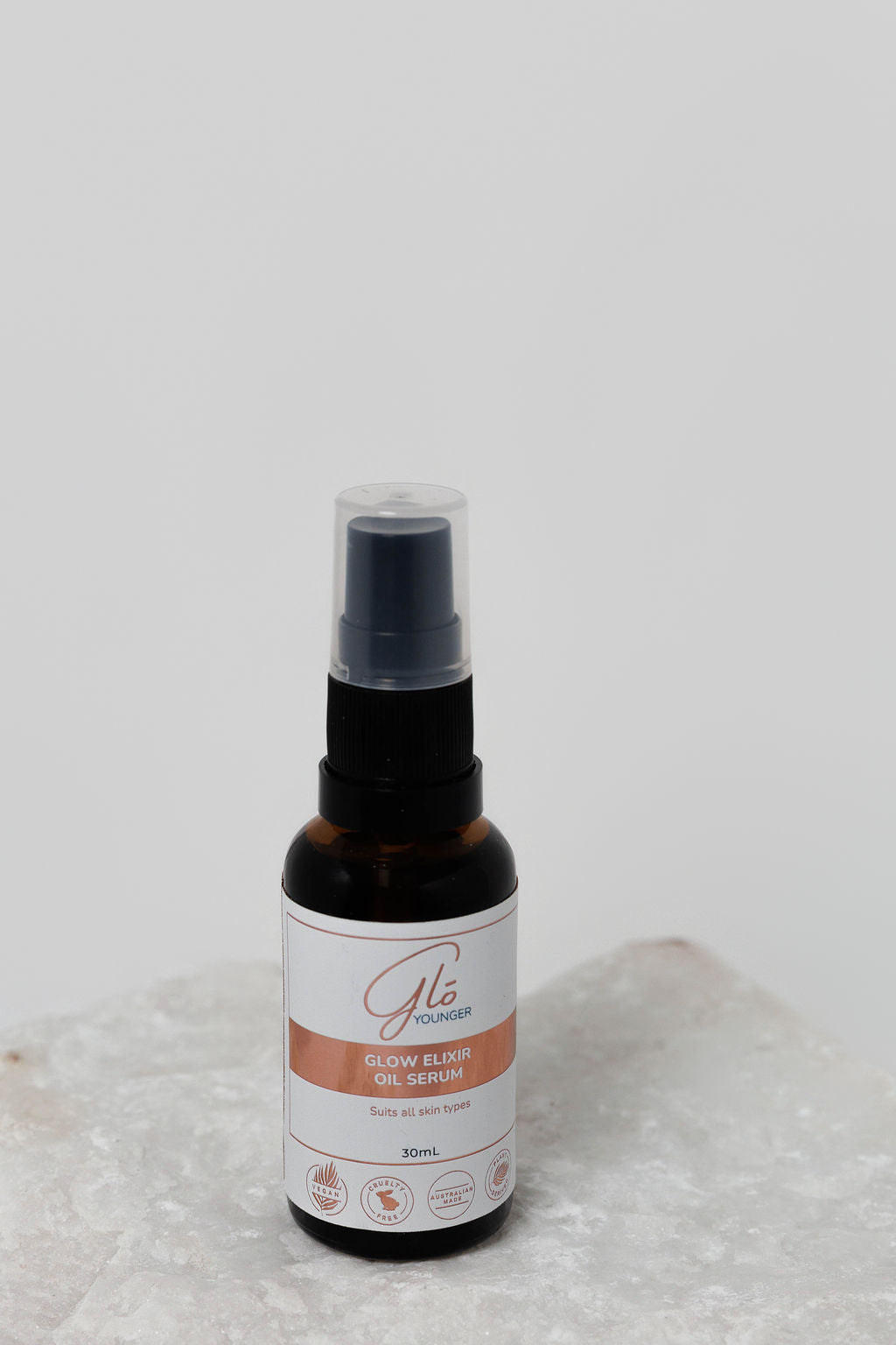 Glo Younger Glow Elixir Oil Serum bottle on stone
