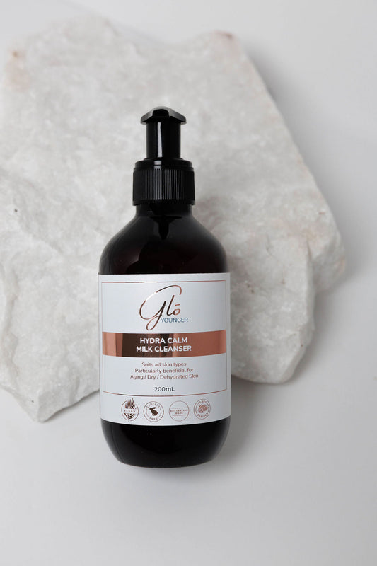 Glo Younger Hydra Calm Milk Cleanser bottle on stone